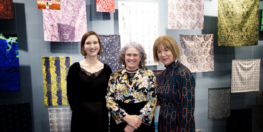 Women in front of tapestry
